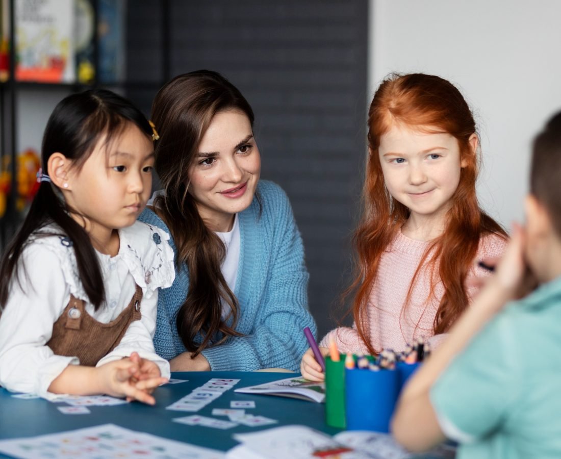 kids-teacher-sitting-together-table